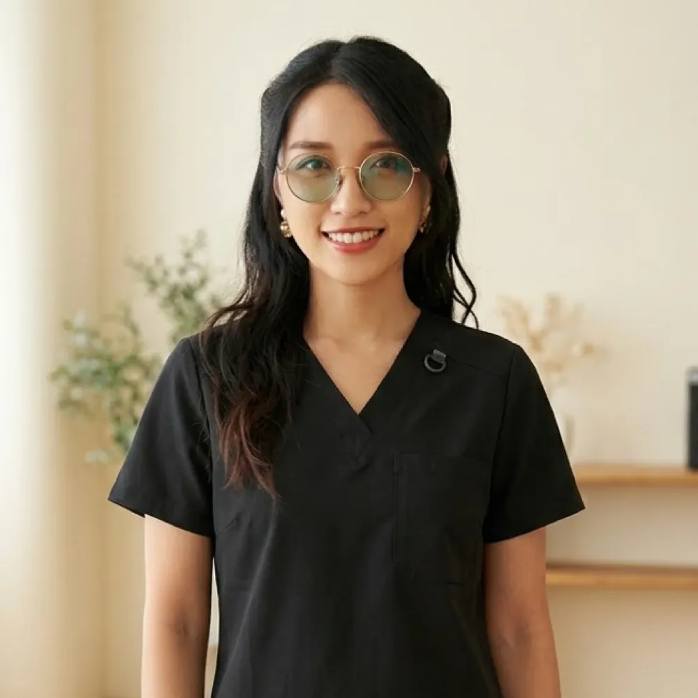 Portrait of founder Nunkanut “Lisa” Sangsiri in black scrubs in the studio
